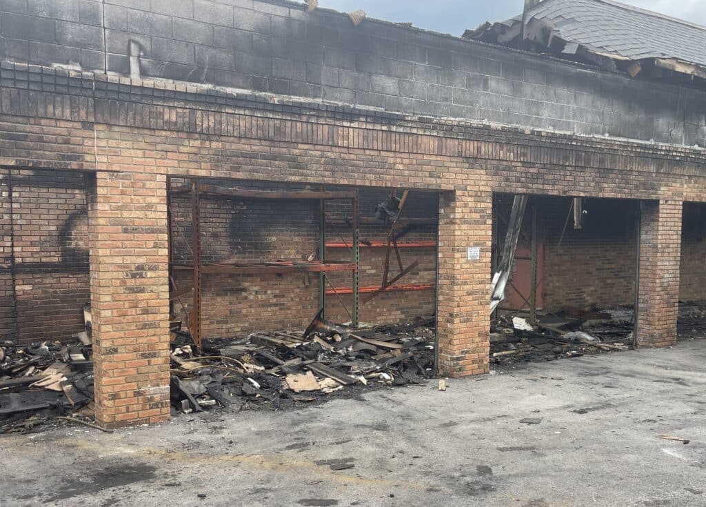 Keystone style pallet rack inside fire-damaged storage space with collapsed roof debris