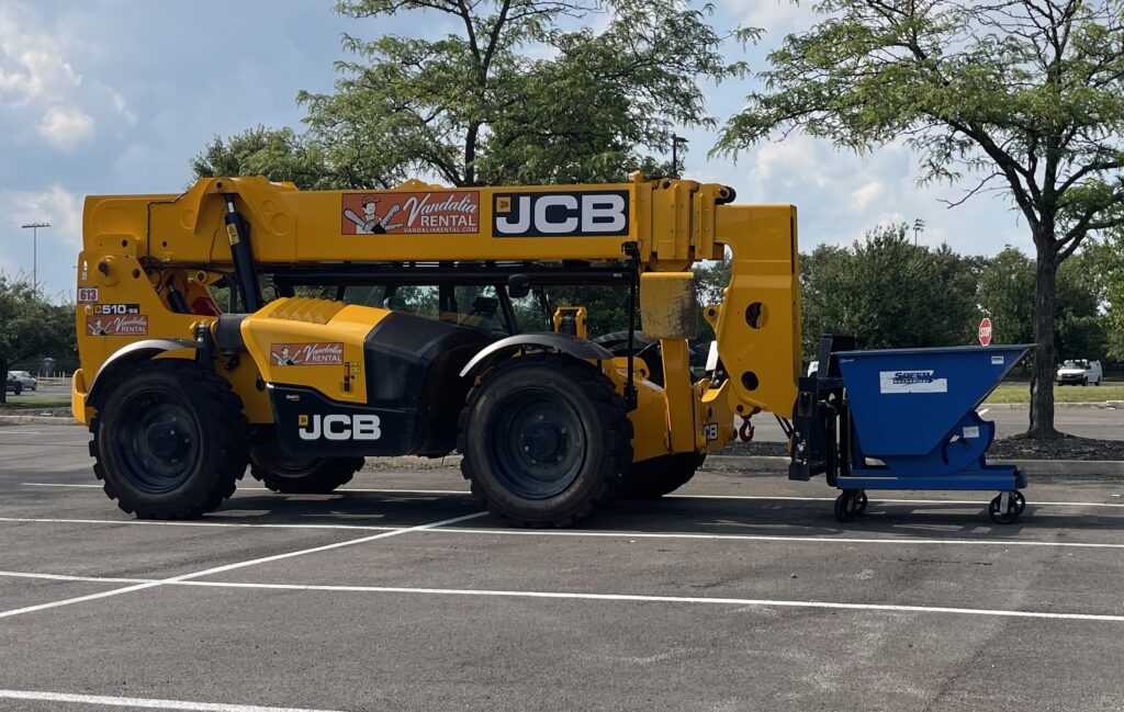 Blue self dumping hopper transporting construction debris during a school renovation project in Columbus, Ohio