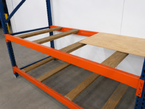 pallet rack with wood pallet supports and partially covered plywood decking, illustrating wood used for pallet rack storage.